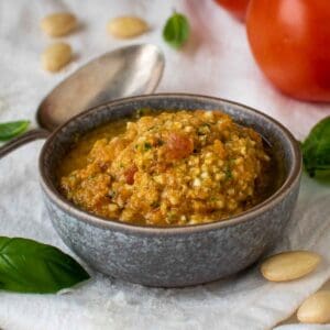 Pesto alla Trapanese in a grey bowl on a white cloth.