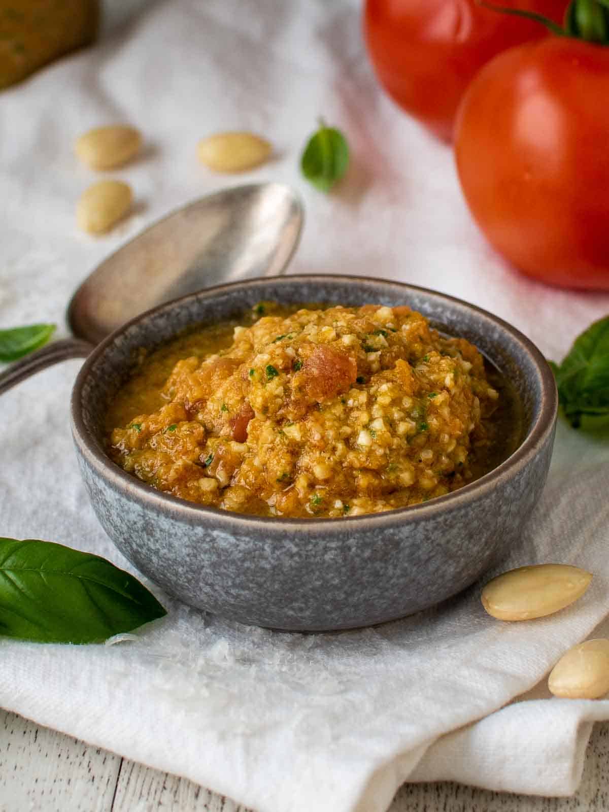 Pesto alla Trapanese in a grey bowl on a white cloth.