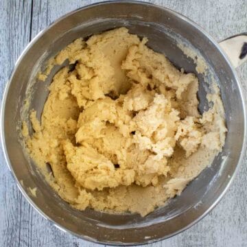 Soft looking, pale yellow dough in the bottom of a steel bowl.