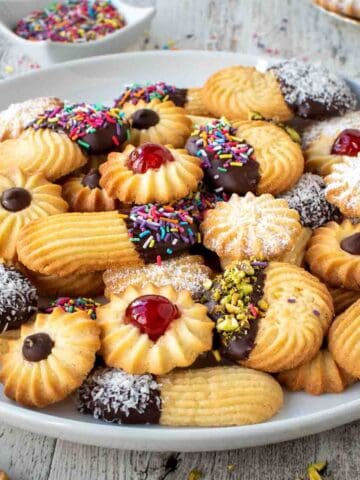 Italian Butter Cookies with various toppings on a white plate.