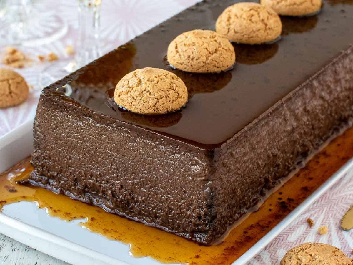 Close up of oblong chocolate dessert with amaretti cookies on top.