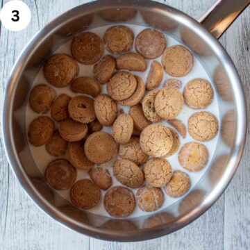 Amaretti cookies floating in a saucepan of milk.