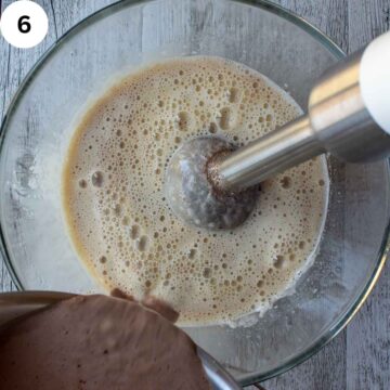 Brown liquid being poured into a light brown liquid.