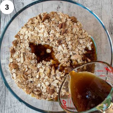 Brown syrupy liquid being poured into old fashioned oats viewed from above.