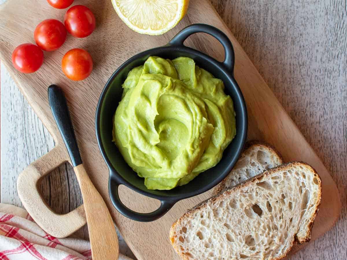 Overhead view of smooth green dip in a black bowl.