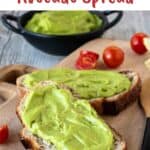 Avocado Spread on two slices of sourdough bread, cherry tomatoes and more spread in background.