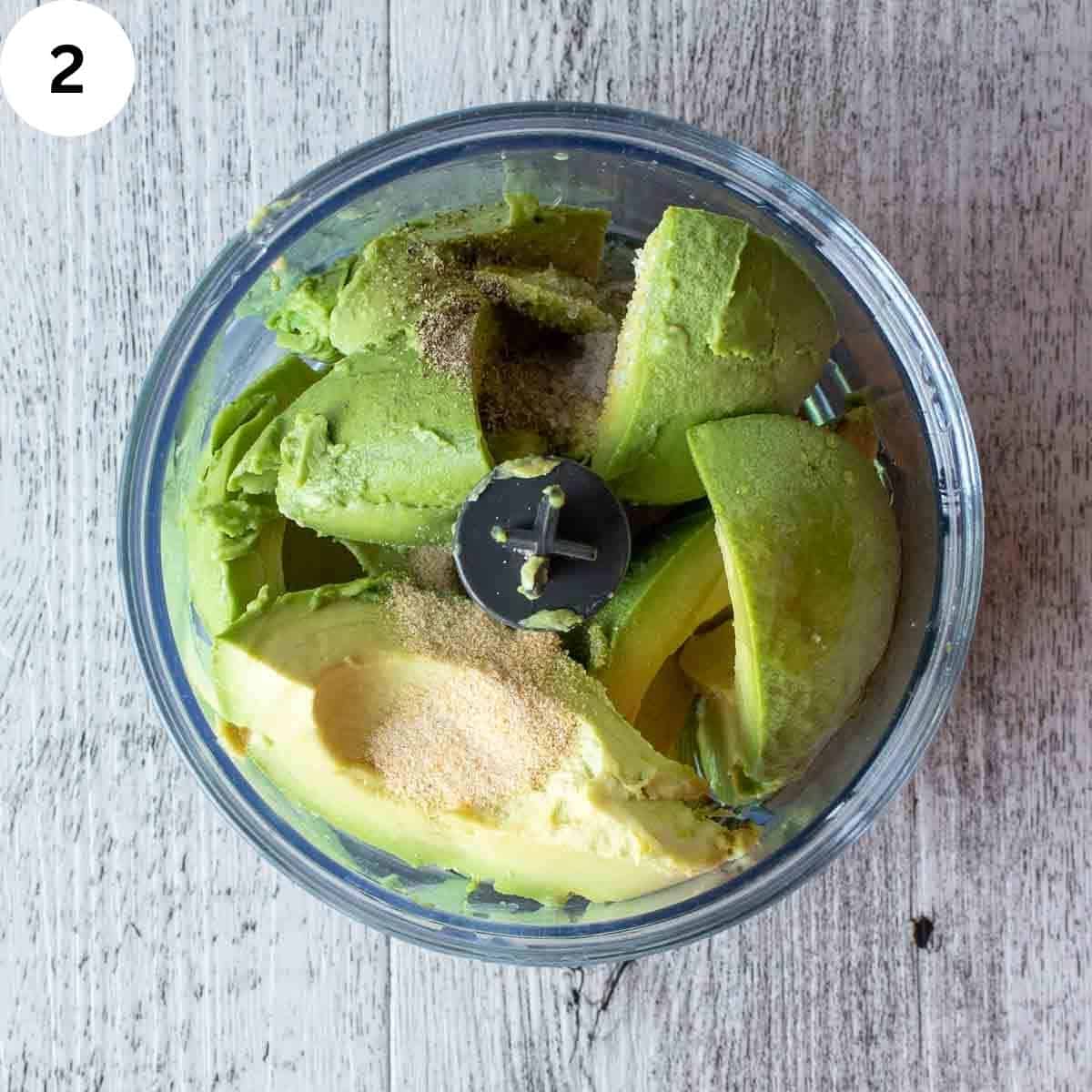 Avocado and other ingredients in a mini food processor.