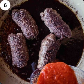 Tomato puree being added to browned beef rolls in a pan.