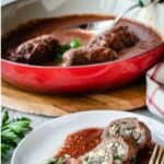 Beef braciole sliced and served on tomato sauce on a white plate.