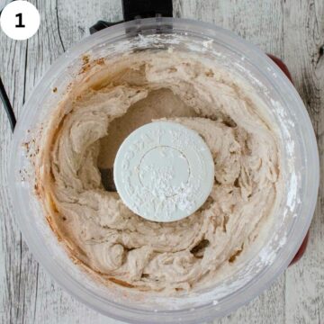 Creamy mixture in a food processor with the lid removed viewed from above.