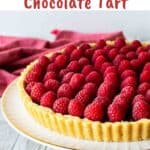 Chocolate Raspberry Tart on a white footed cake plate.