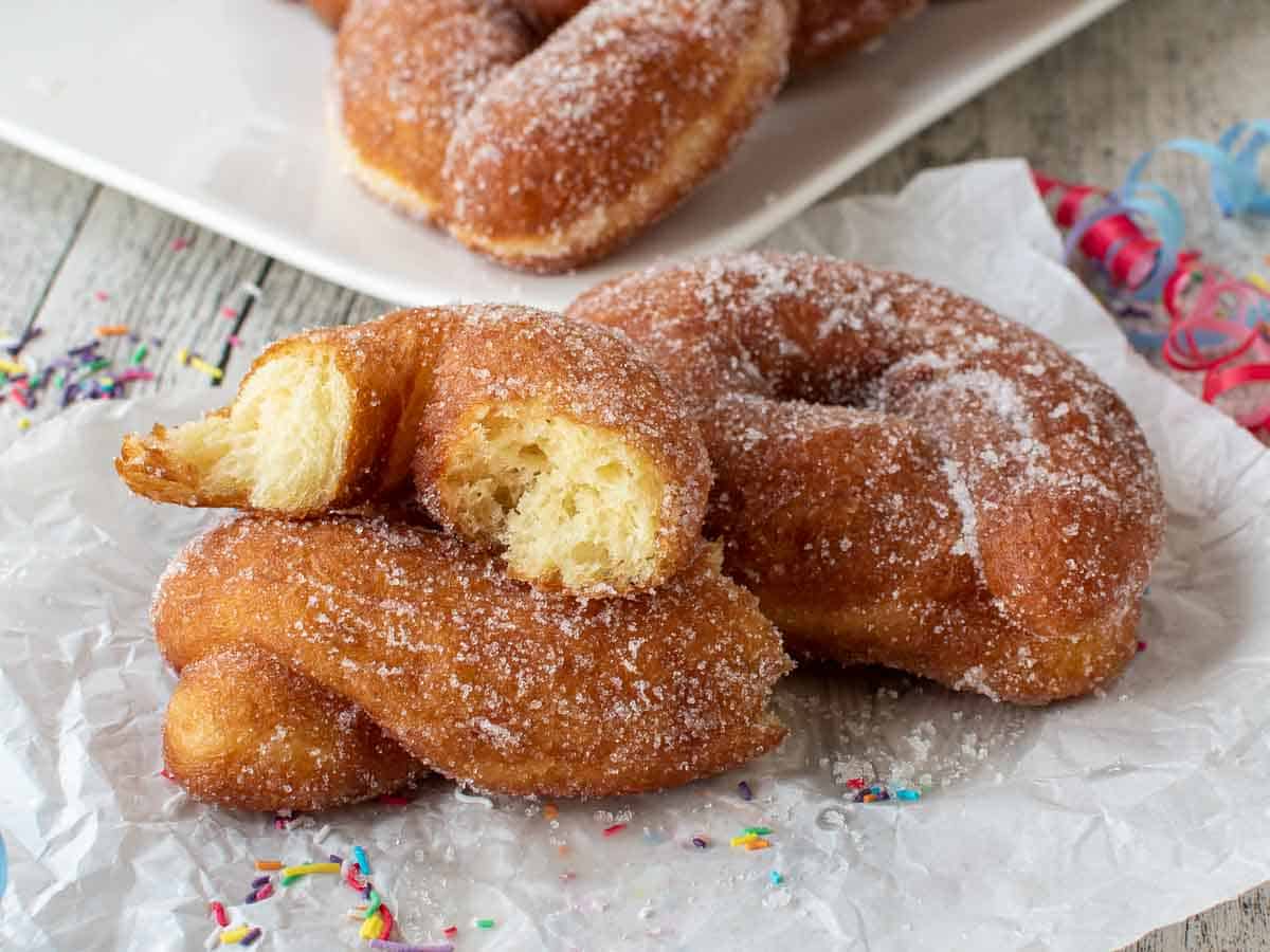 Potato Donuts broken in half to show inside and more donuts in the background.