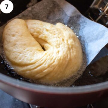 Risen doughnut floating in hot oil.