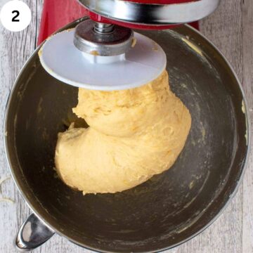 Soft dough wrapped around the dough hook of an electric mixer.