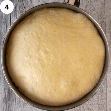 Puffed up dough in a stainless steel bowl.