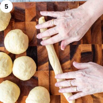 Dough balls on a wooden surface with a rope of dough being rolled by hand.