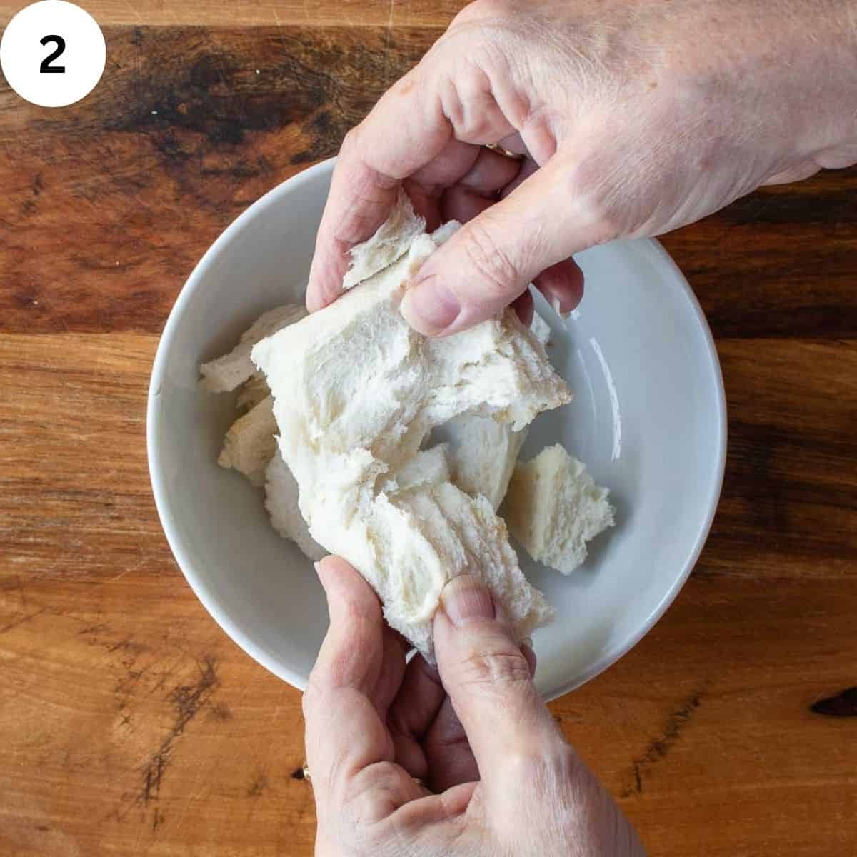 Bread being broken by hands.