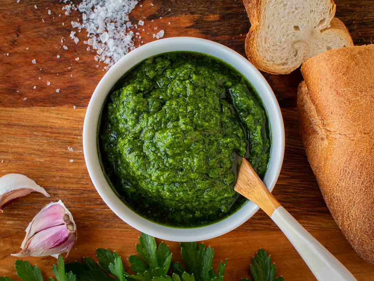 Thick Italian parsley sauce in a bowl with a spoon in it.