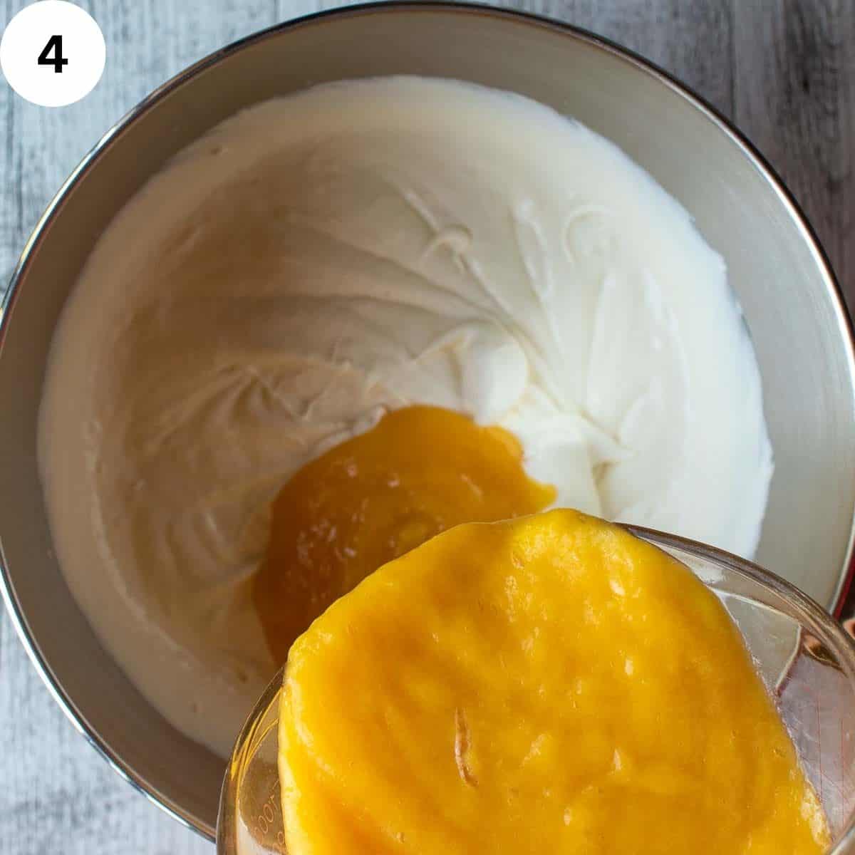 Pouring mango puree into thick cream.