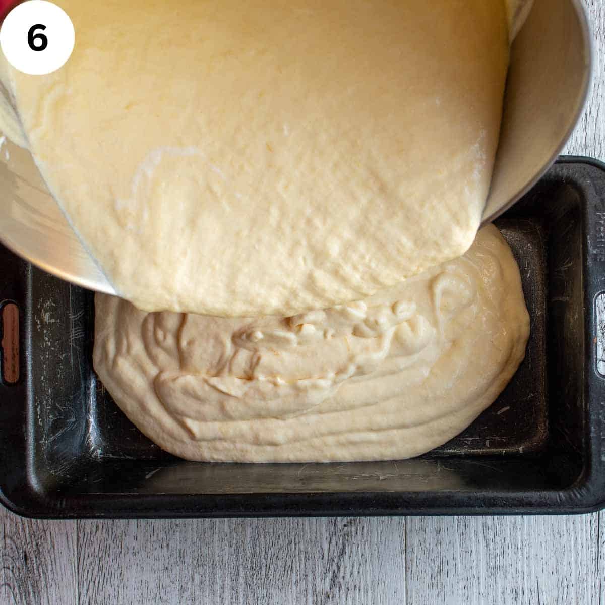 Pouring thick, creamy, pale yellow mixture into a loaf pan.