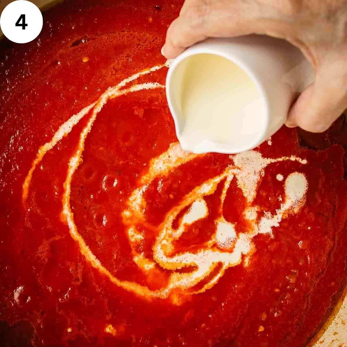 Drizzling cream into tomato sauce.