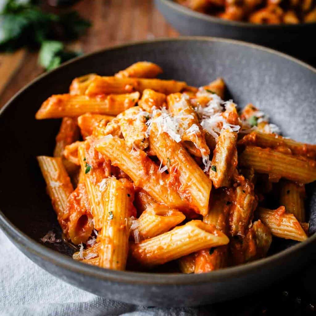 Chicken and Vodka Pasta in a shallow bowl with another bowl in the background.