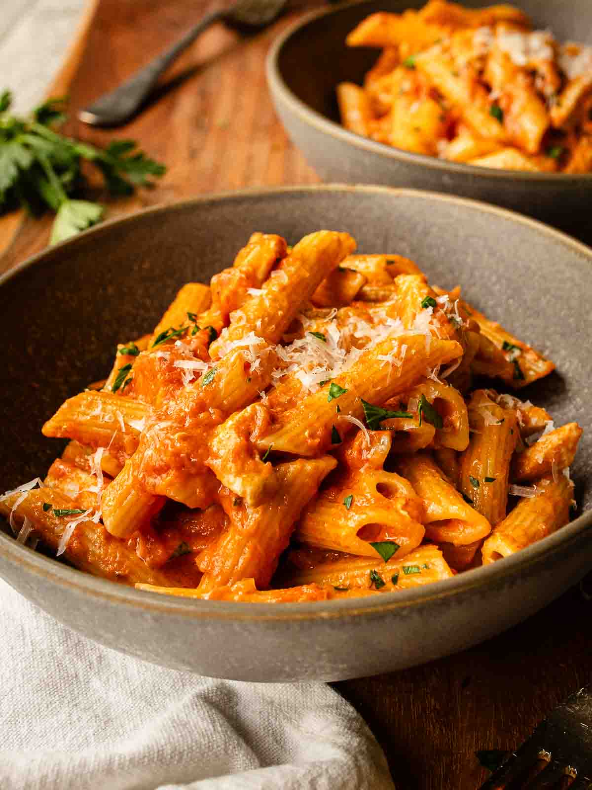 Chicken and Vodka Pasta in a shallow bowl with another bowl in the background.