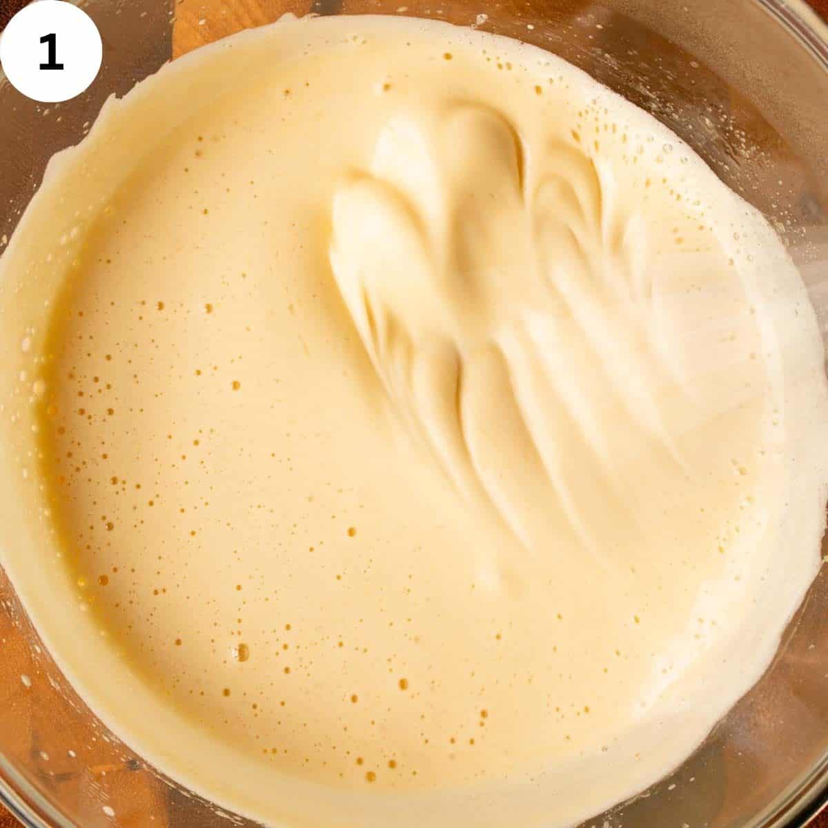 Thick, creamy, yellow mixture being whisked.