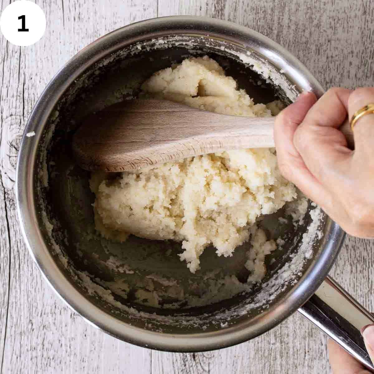 Stirring thick white mixture in a saucepan.