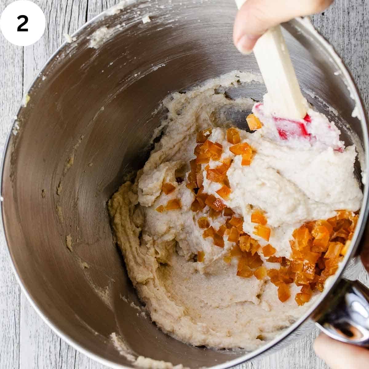 Stirring orange bits into a creamy mixture.