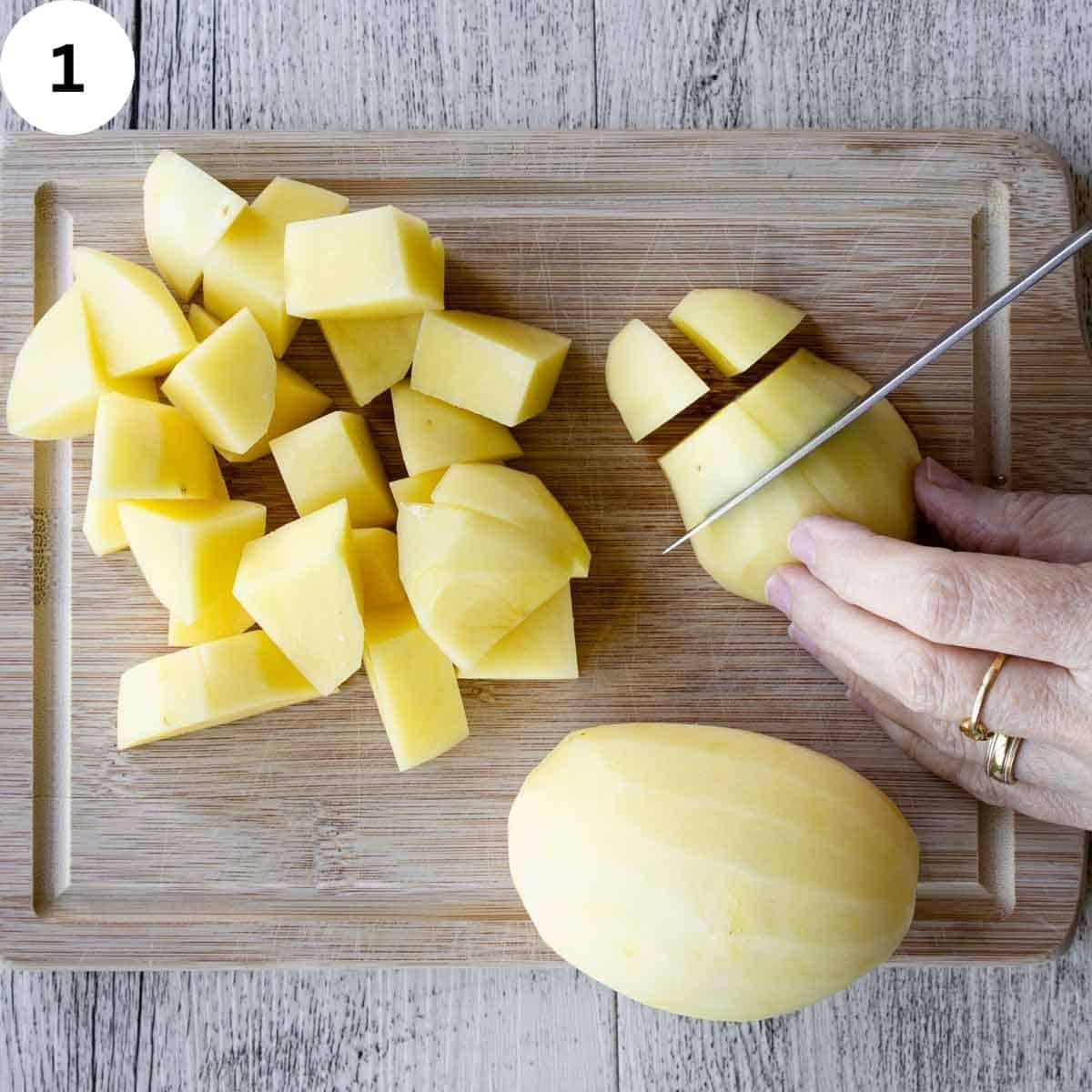 Cutting peeled potatoes into cubes.