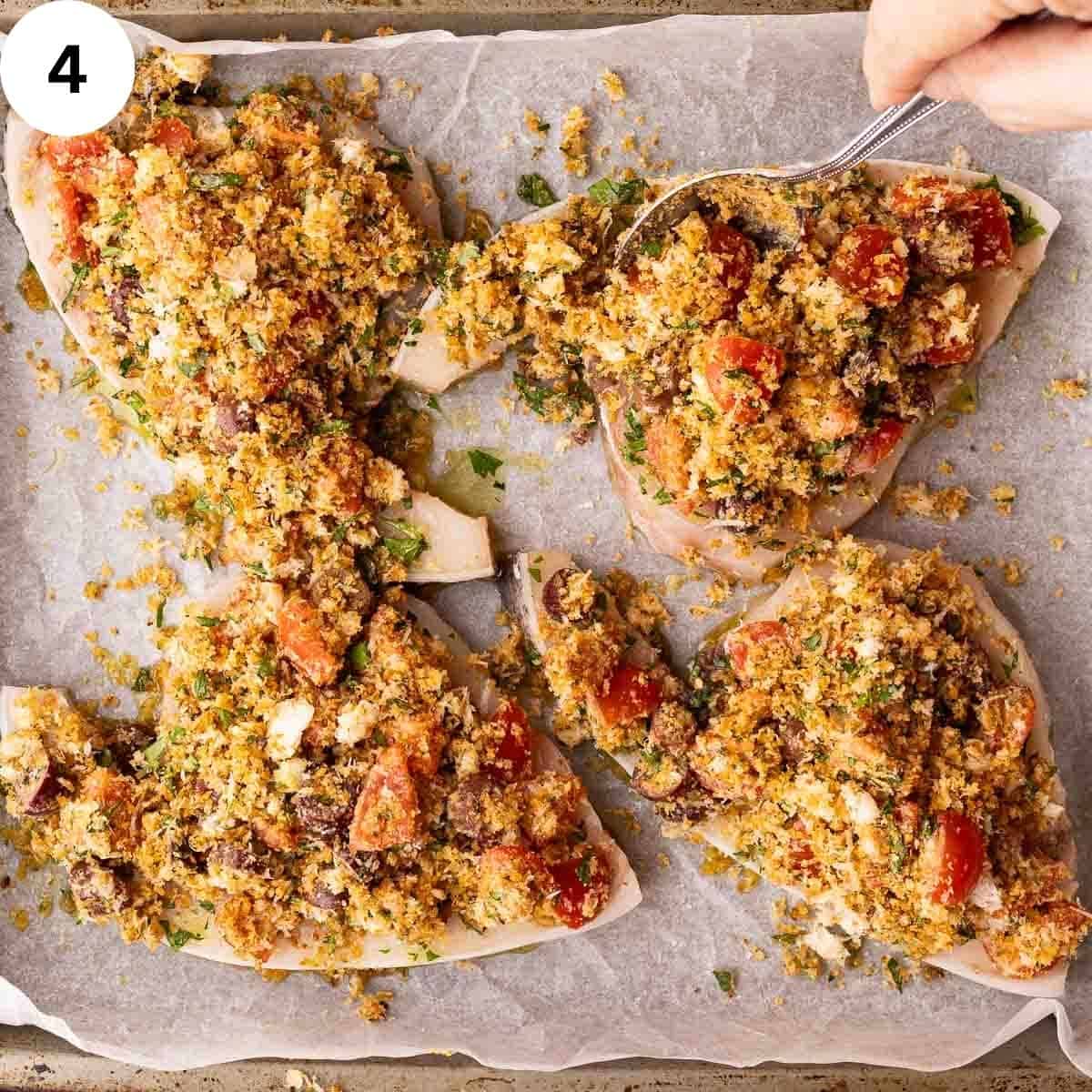 Spooning breadcrumb topping over swordfish steaks.