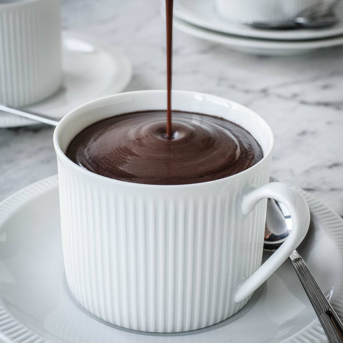 Italian Hot Chocolate being poured from a jug into a cup.