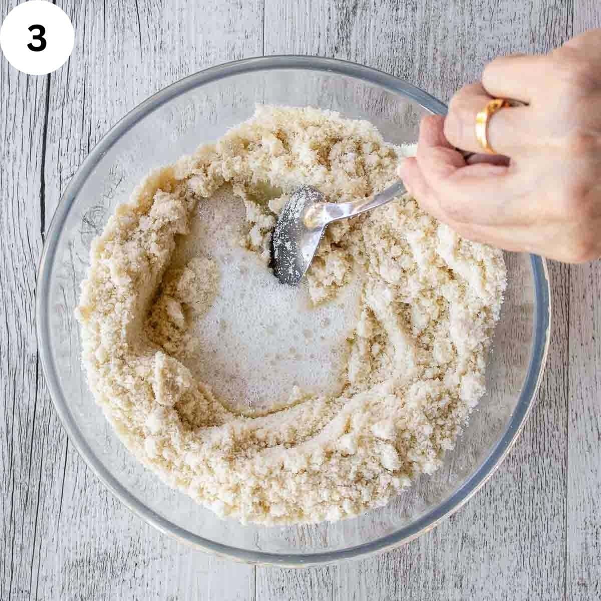 Stirring frothy egg white into dry ingredients.
