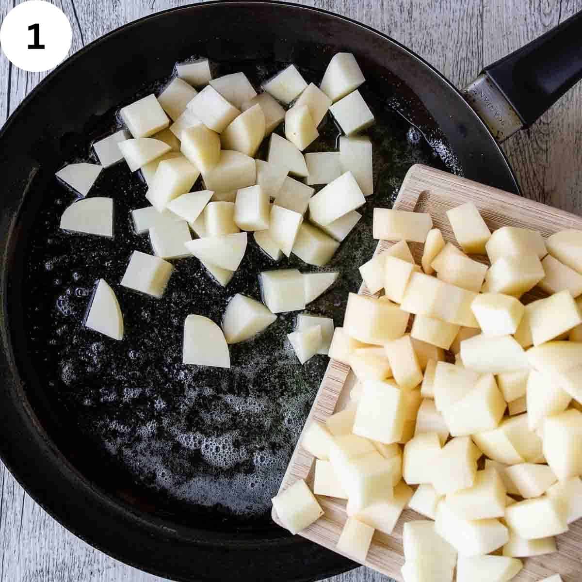 Adding cubes of potatoes to a skillet.