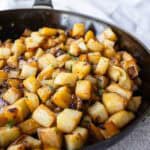 Fried potatoes and onions in a skillet.
