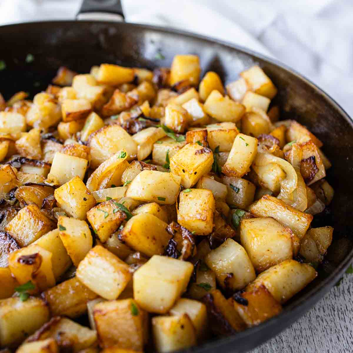 Fried potatoes and onions in a skillet.