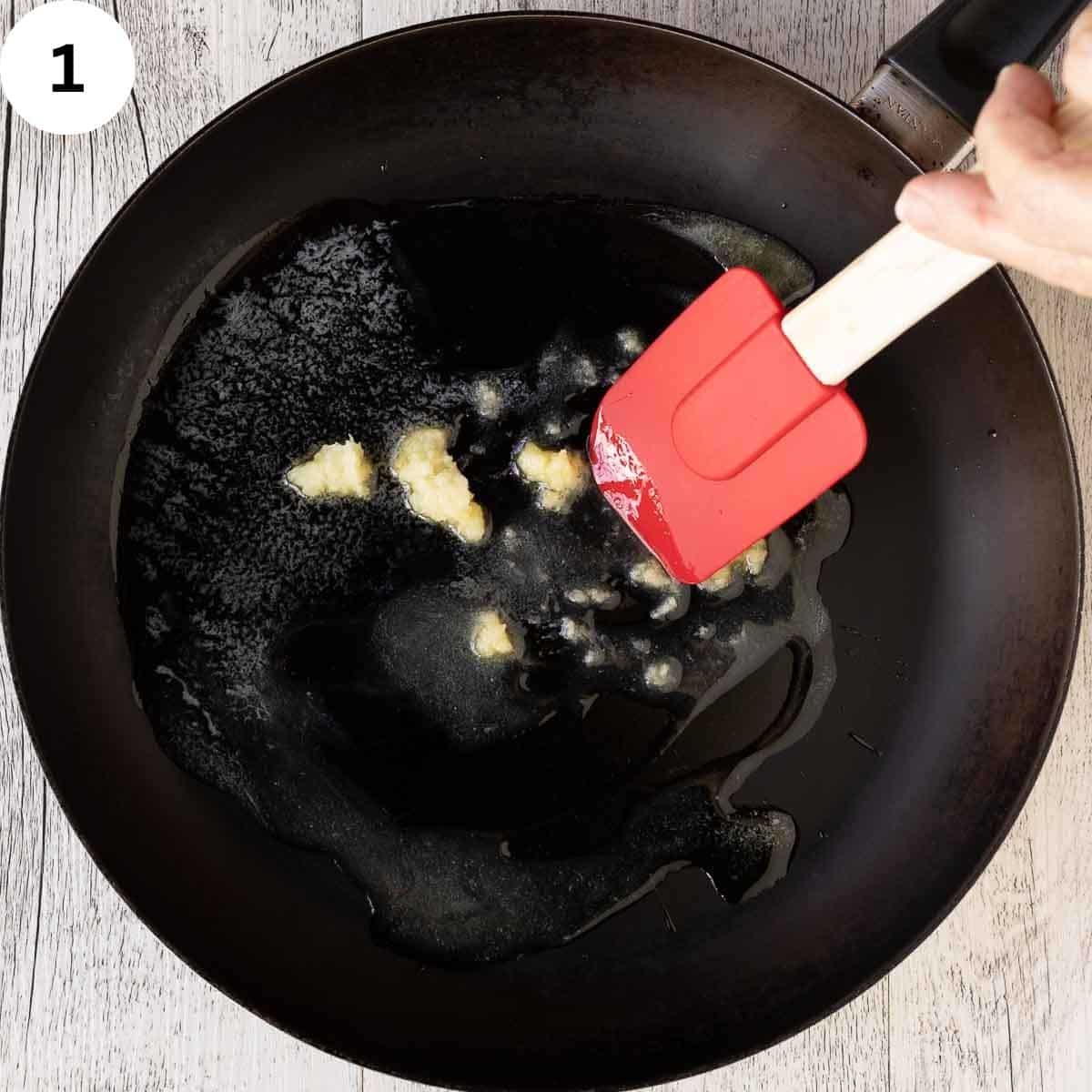 Minced garlic being sautéed in a skillet.