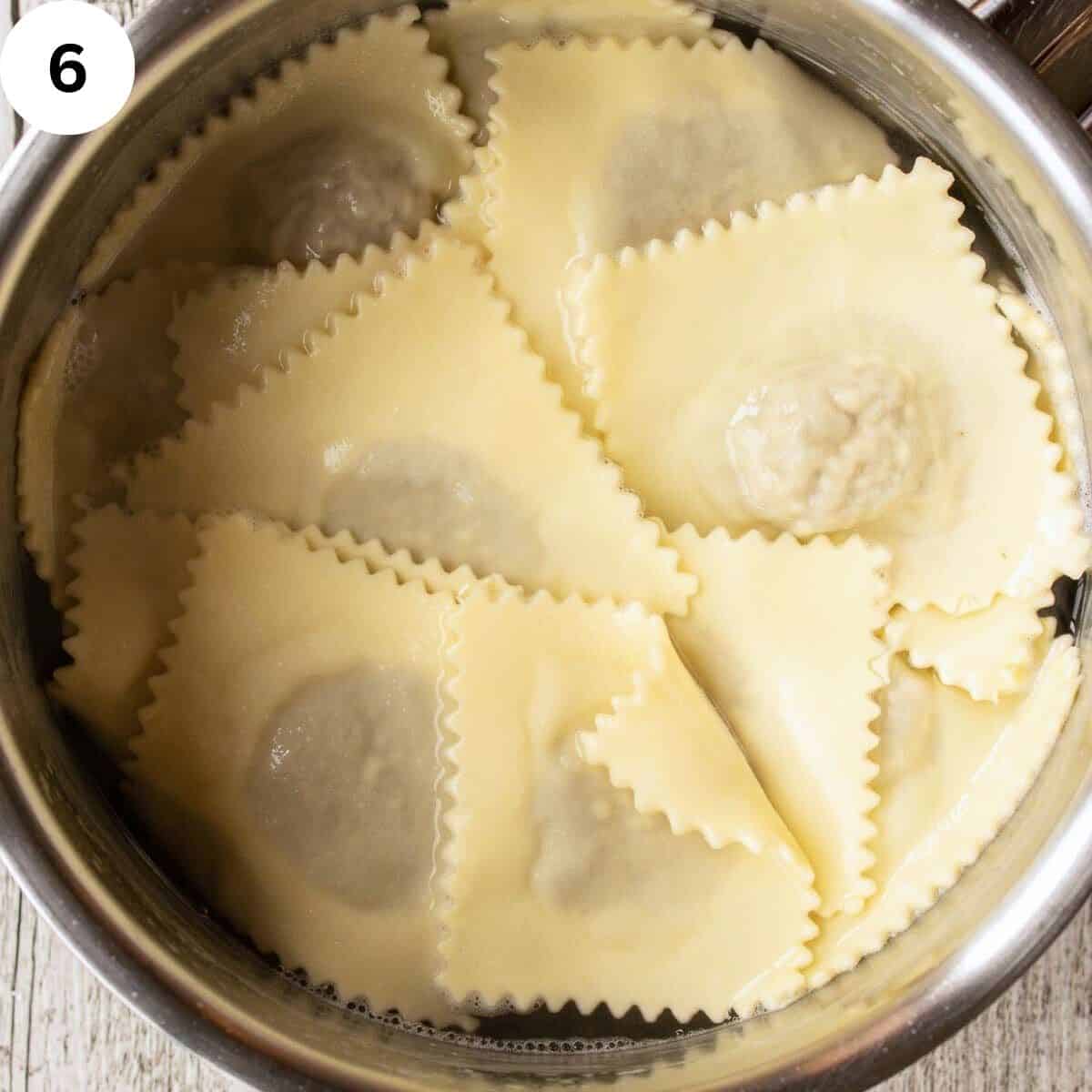 Ravioli in a pot filled with water.
