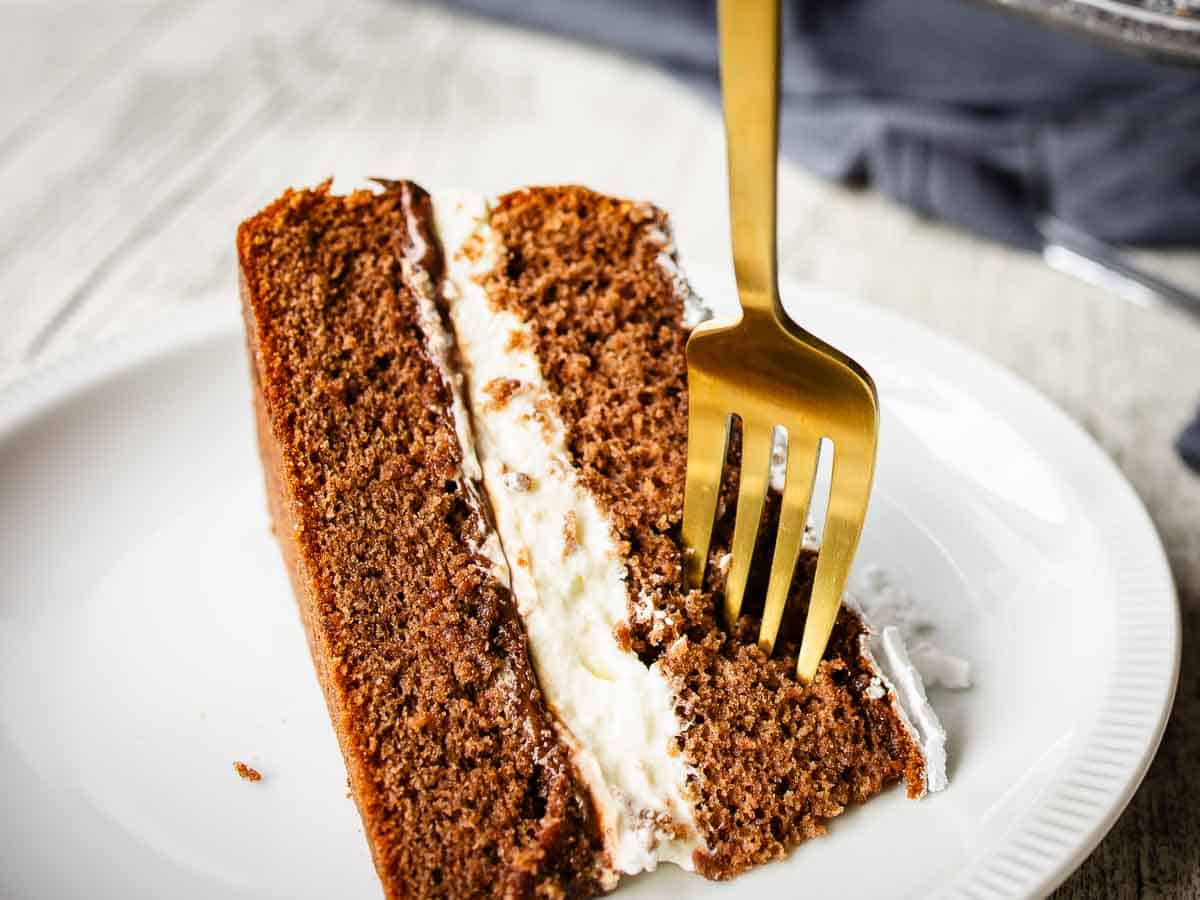 Close up of a wedge of two layered chocolate cake filled with Nutella and cream.