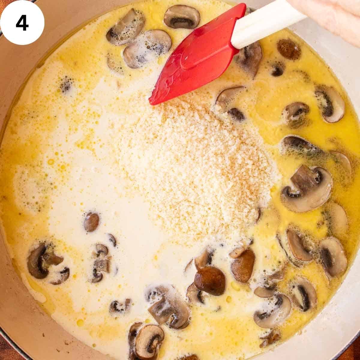 Grated parmesan cheese being stirred into a creamy sauce.