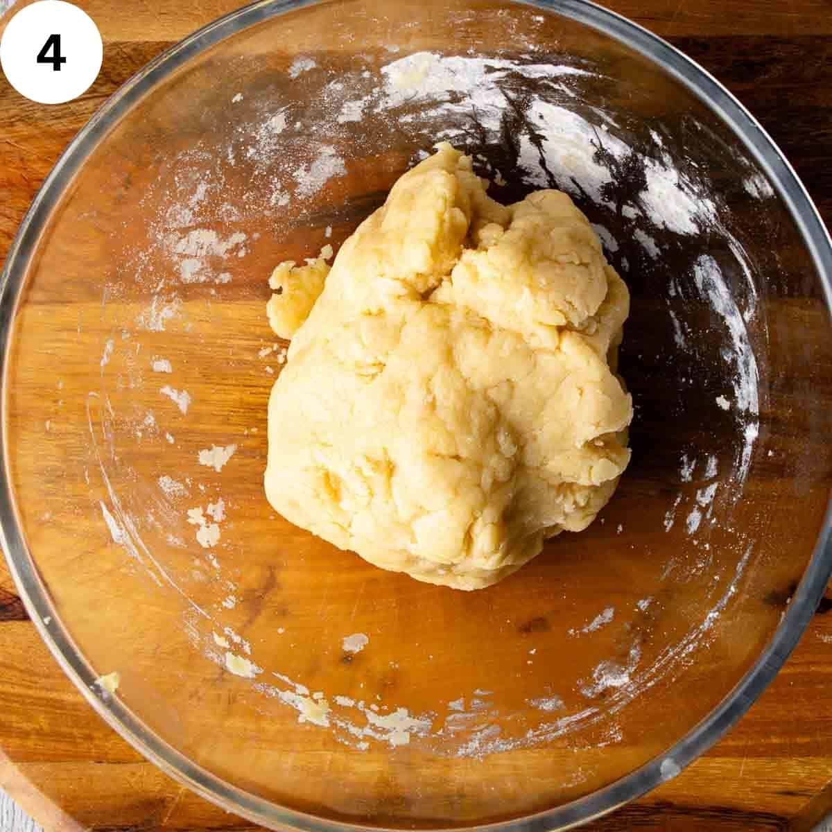 Uncooked dough ball in a glass bowl.