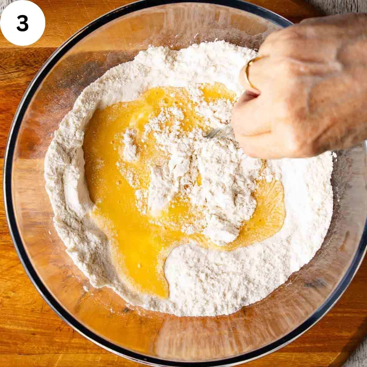 Stirring beaten eggs into flour.
