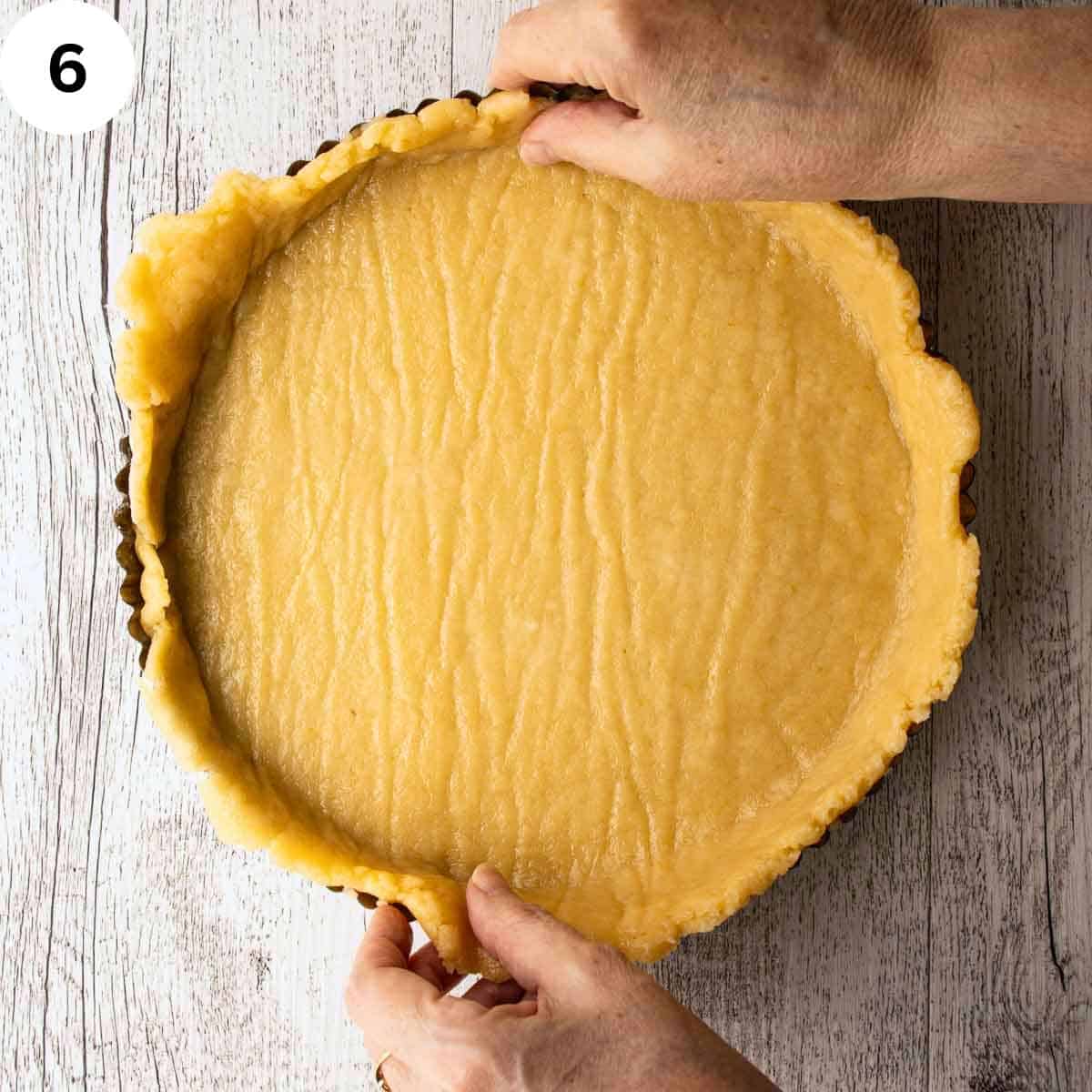 Lining a flan pan with pastry.