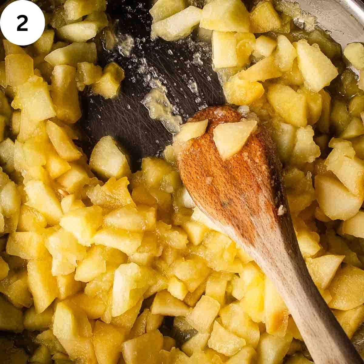 Stirring cooked chopped apples.