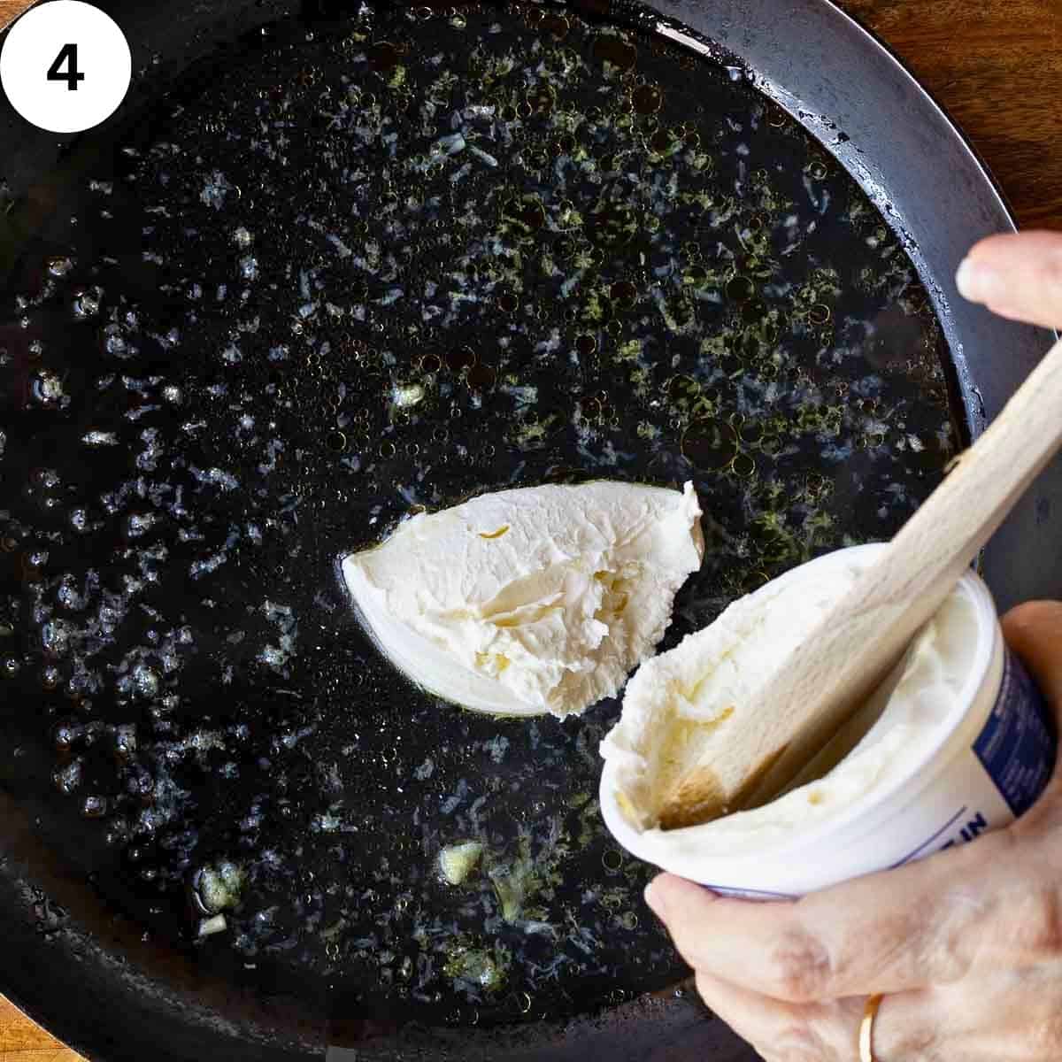 Cream cheese being added into a skillet.