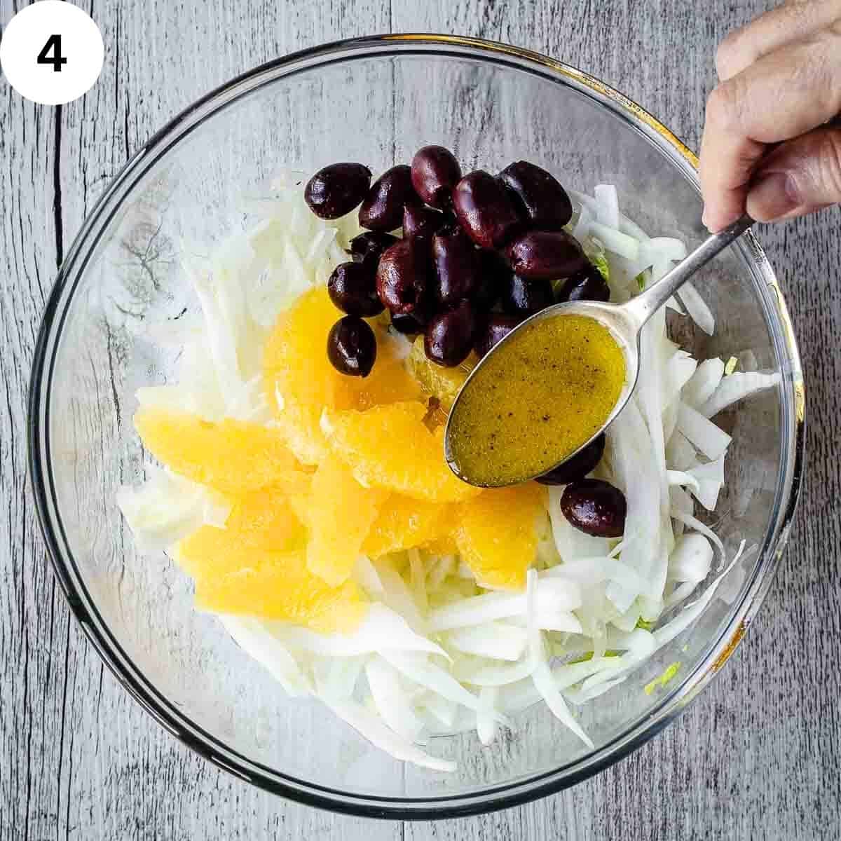 Pouring salad dressing over slice fennel, orange and black olives.