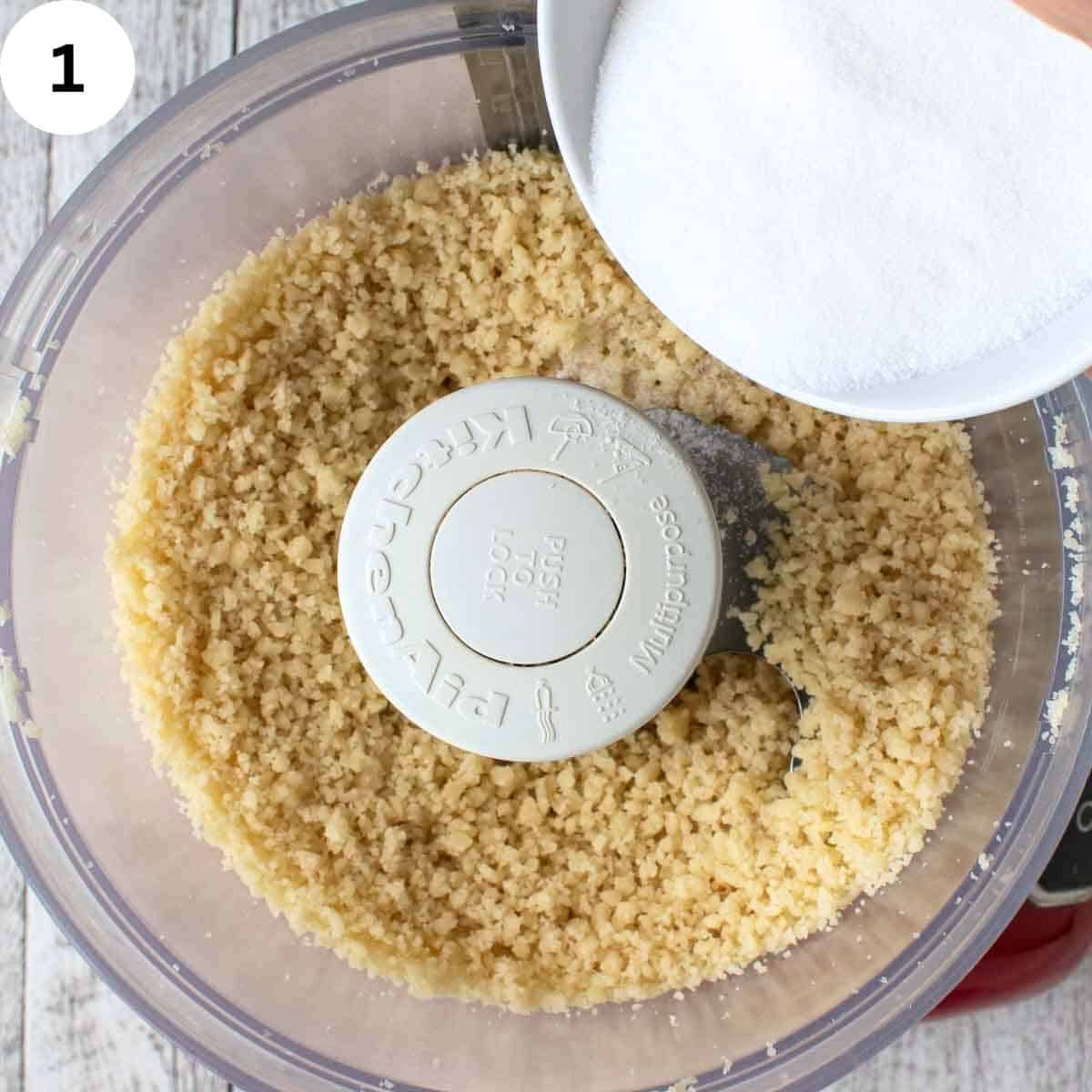 Sugar being added to crumbly mixture in food processor.