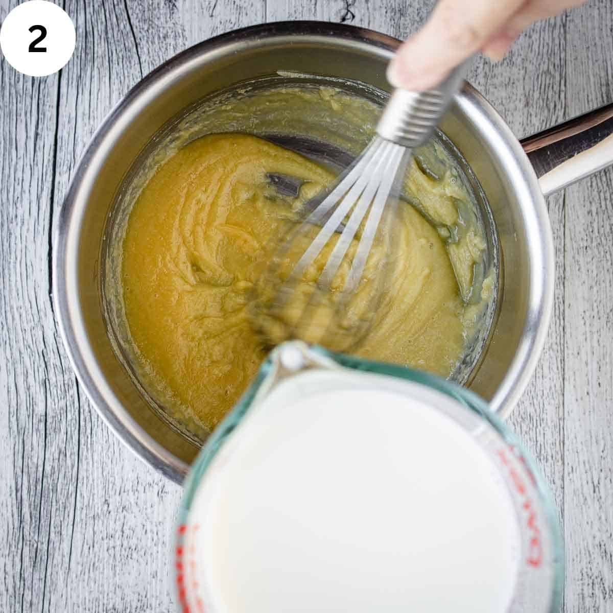 Whisking milk into a roux.