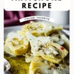 Close up of marinated artichokes plied onto a plate.